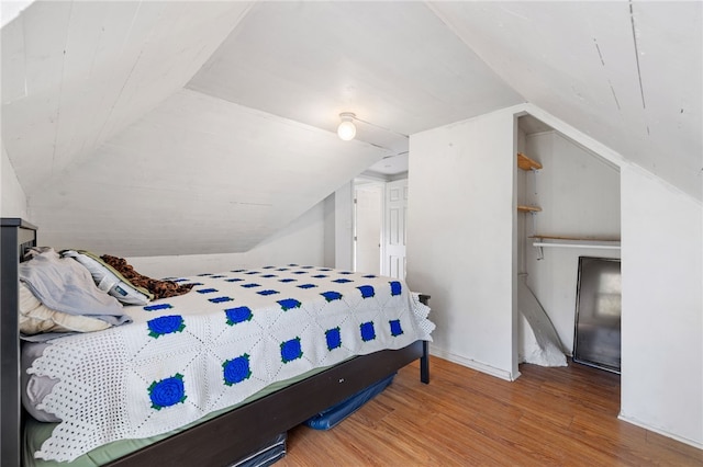 bedroom featuring vaulted ceiling and wood-type flooring