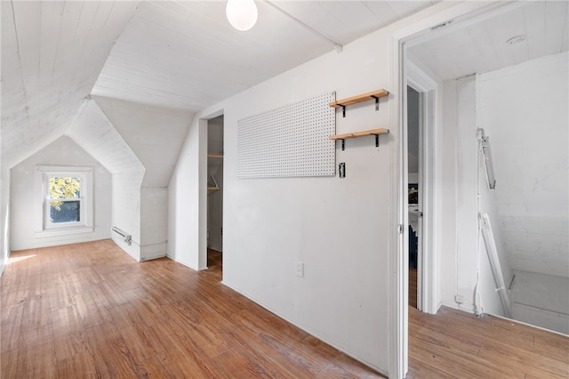 additional living space with lofted ceiling and light hardwood / wood-style flooring