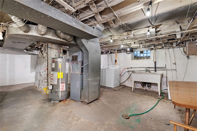 basement featuring sink, heating unit, separate washer and dryer, and water heater