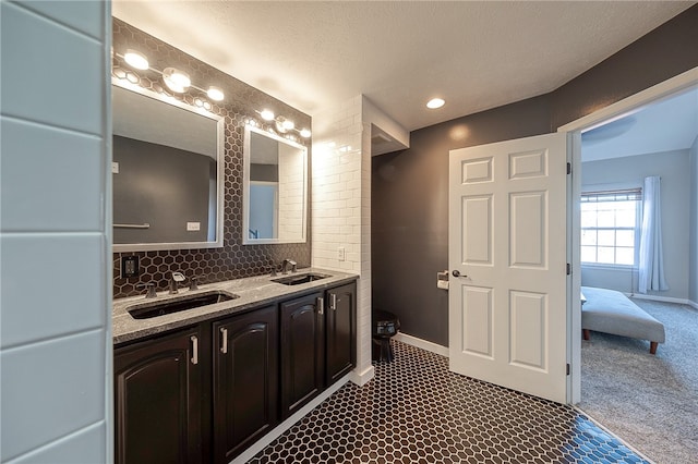 bathroom with vanity, decorative backsplash, and a textured ceiling