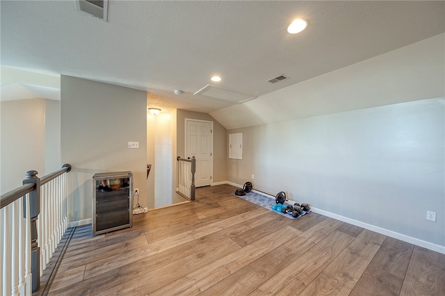 bonus room with lofted ceiling and light wood-type flooring