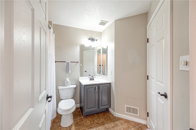 bathroom featuring vanity, a textured ceiling, toilet, and tile patterned flooring