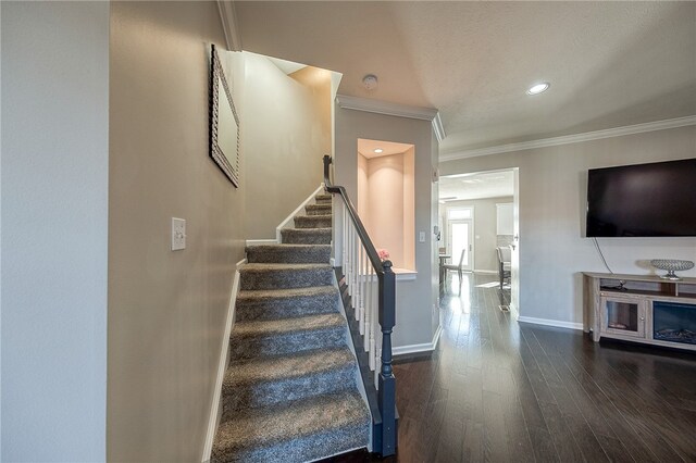 stairway featuring ornamental molding and hardwood / wood-style flooring