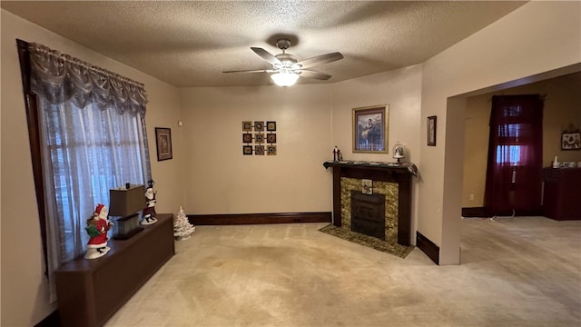 living room with ceiling fan, carpet floors, a textured ceiling, and a high end fireplace