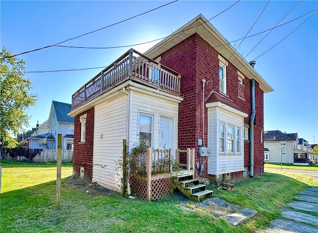 back of property with a balcony and a yard