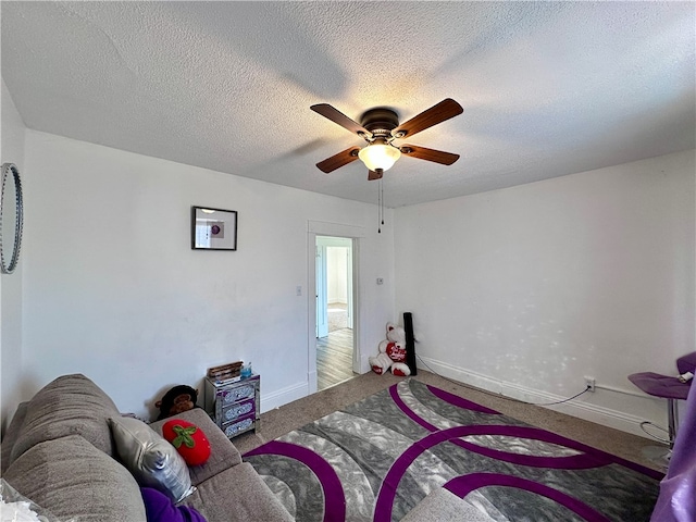 bedroom with ceiling fan, carpet, and a textured ceiling