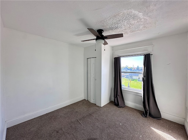 unfurnished bedroom featuring a closet, ceiling fan, a textured ceiling, and carpet floors