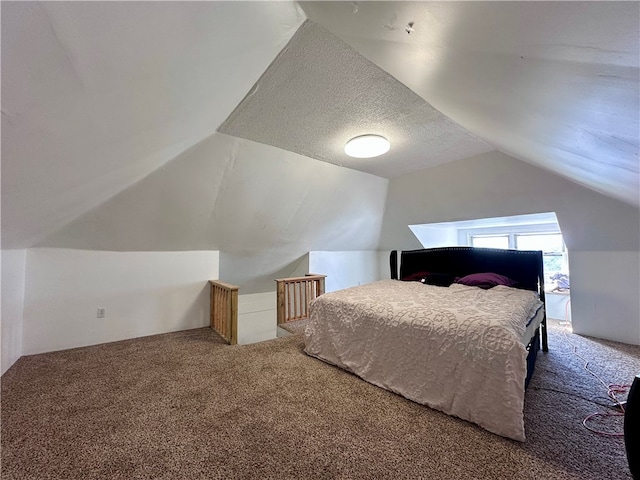 bedroom with lofted ceiling, carpet floors, and a textured ceiling