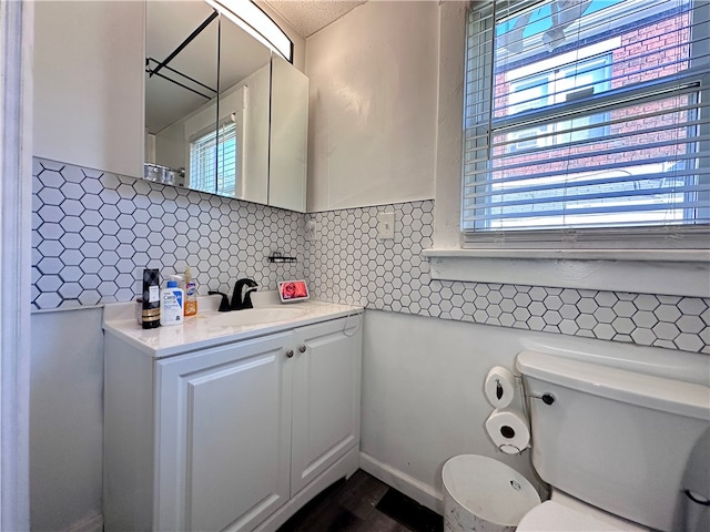 bathroom featuring vanity, toilet, and a wealth of natural light