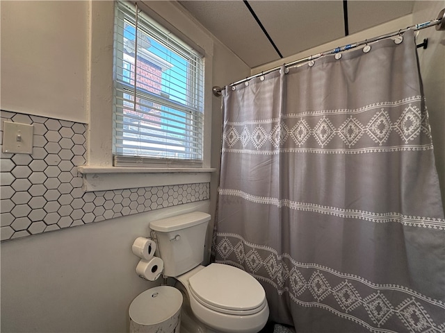 bathroom featuring toilet and curtained shower