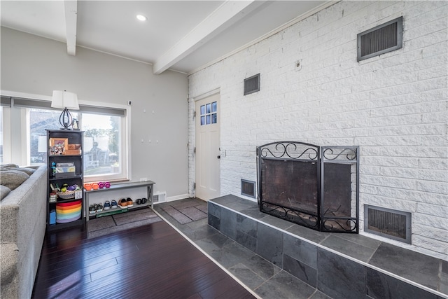 living room with beamed ceiling, dark hardwood / wood-style flooring, and a tile fireplace