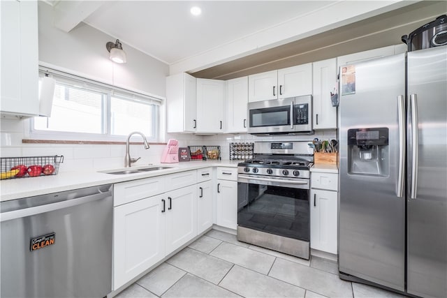 kitchen featuring backsplash, sink, appliances with stainless steel finishes, and white cabinets