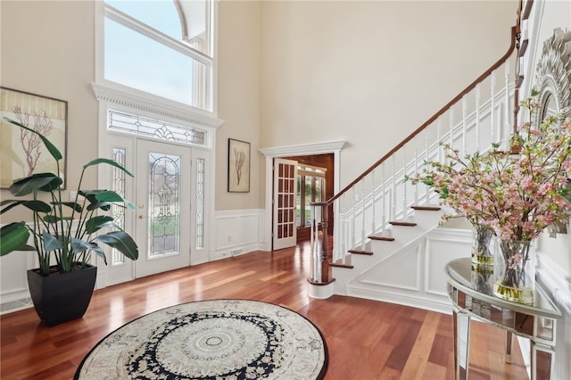 foyer featuring a wealth of natural light, a high ceiling, and wood-type flooring