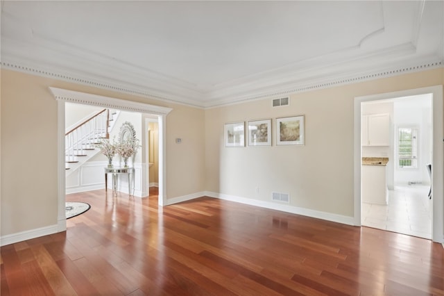 spare room with crown molding, hardwood / wood-style flooring, and a tray ceiling