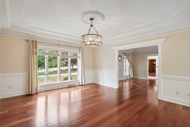 spare room featuring crown molding, a notable chandelier, and dark hardwood / wood-style flooring