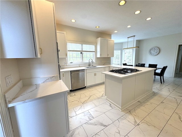 kitchen with white cabinets, stainless steel appliances, a wealth of natural light, and pendant lighting