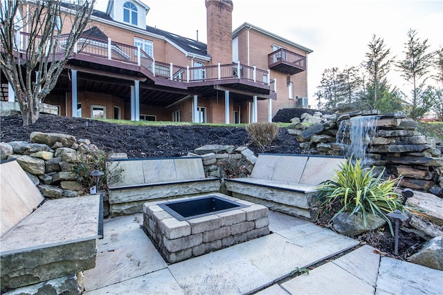 view of patio / terrace with a wooden deck and an outdoor fire pit