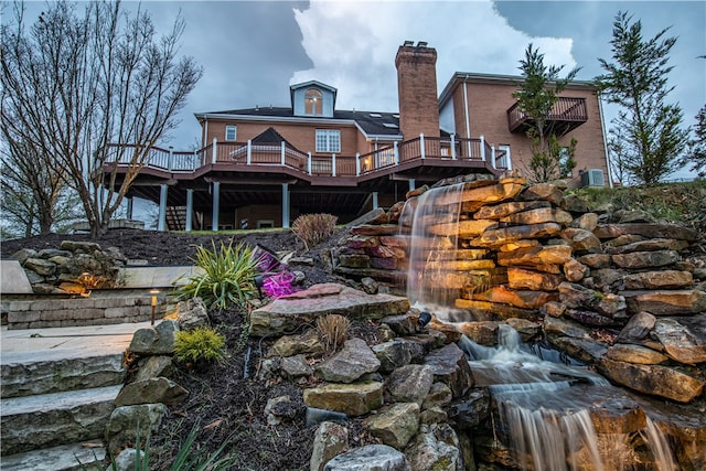 back of property with a wooden deck and cooling unit