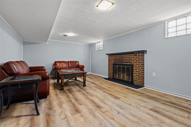 living room with ornamental molding, light wood-type flooring, and a fireplace