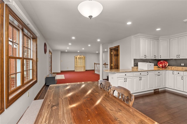 dining space with ornate columns and dark hardwood / wood-style flooring