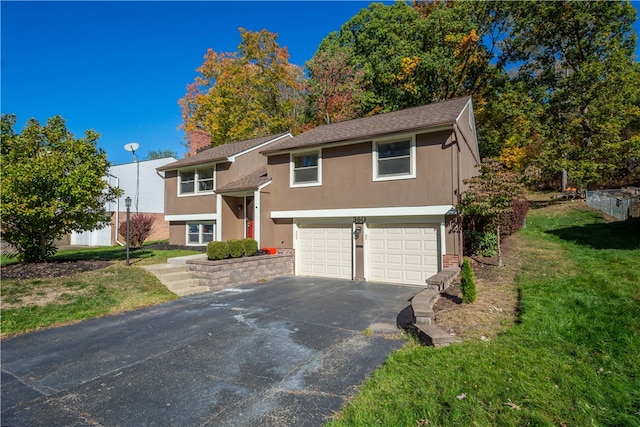 split foyer home featuring a garage and a front lawn