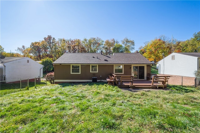 rear view of property with a wooden deck and a lawn