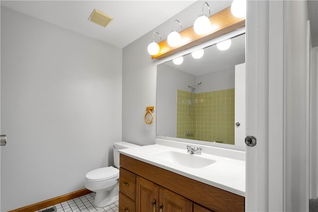 bathroom with toilet, a tile shower, vanity, and tile patterned floors