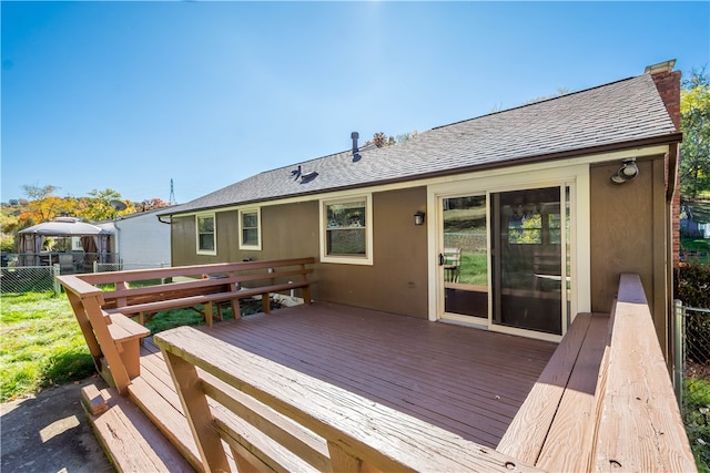 back of property featuring a wooden deck and a gazebo