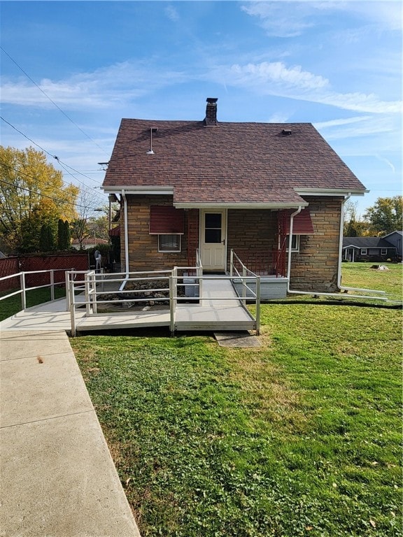 rear view of house featuring a deck and a yard