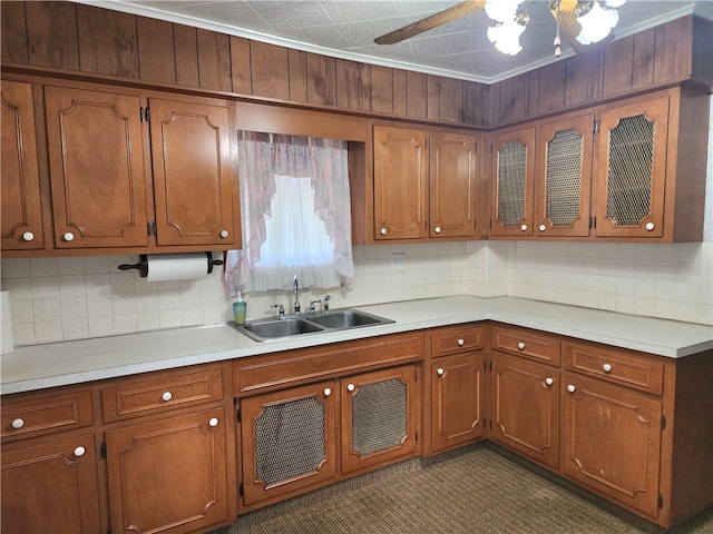 kitchen featuring crown molding, decorative backsplash, and sink