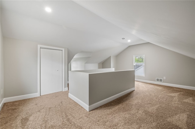 additional living space with carpet floors and vaulted ceiling