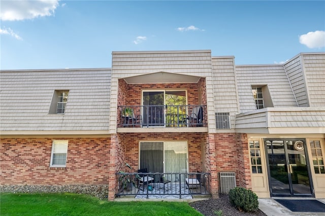 rear view of property featuring a balcony and a patio