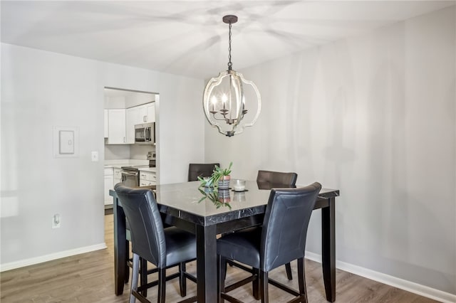 dining room featuring wood-type flooring and a chandelier