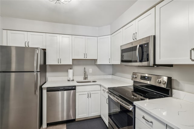 kitchen featuring light stone countertops, sink, white cabinets, and stainless steel appliances