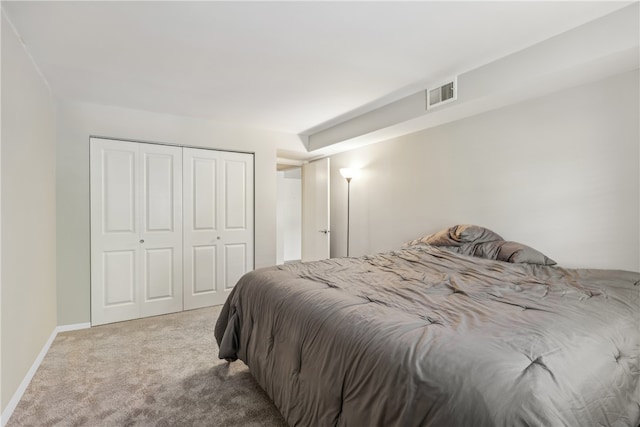 bedroom with a closet and light carpet