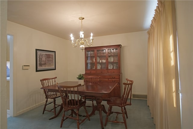 dining room featuring a notable chandelier and dark carpet