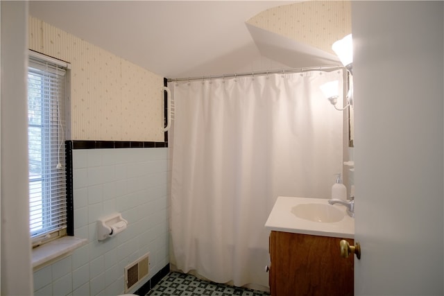 bathroom featuring tile walls, vanity, and walk in shower