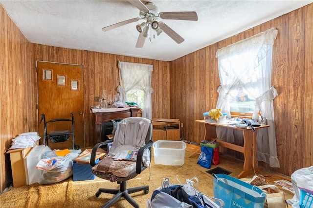 miscellaneous room with ceiling fan, a wealth of natural light, and wooden walls