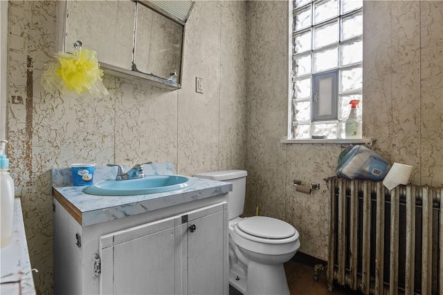 bathroom with vanity, radiator heating unit, and toilet