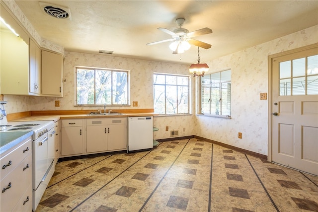 kitchen featuring hanging light fixtures, white appliances, sink, white cabinetry, and ceiling fan with notable chandelier