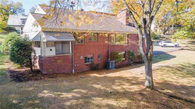 view of side of property featuring central AC, a yard, and a sunroom