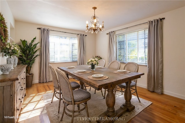 dining room with light hardwood / wood-style flooring, an inviting chandelier, and plenty of natural light