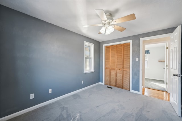 unfurnished bedroom with a closet, ceiling fan, and light colored carpet