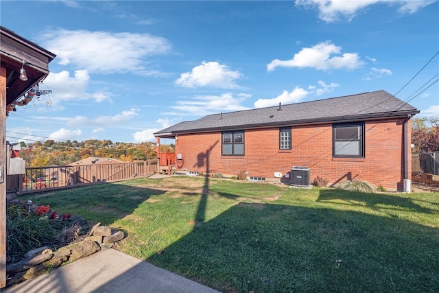 rear view of property with a yard and central AC unit