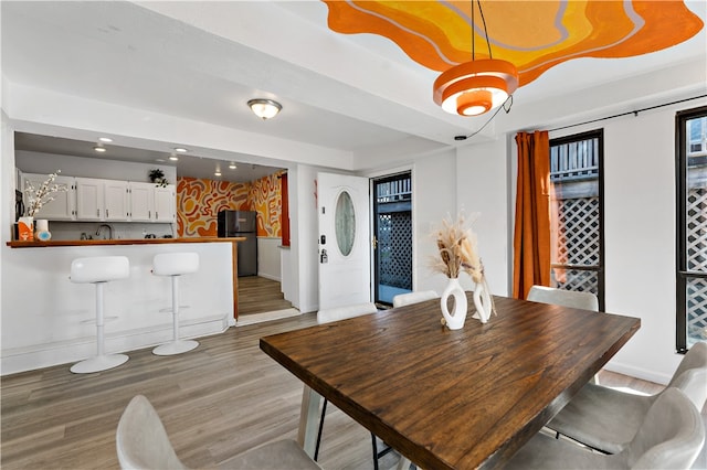 dining space with light hardwood / wood-style floors and sink