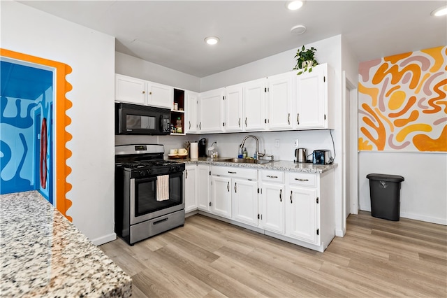 kitchen with sink, stainless steel range with gas cooktop, light hardwood / wood-style flooring, and white cabinetry