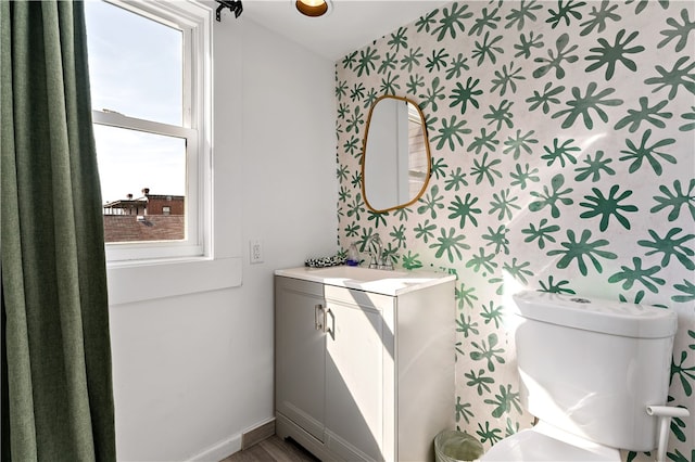 bathroom featuring a healthy amount of sunlight, vanity, and toilet