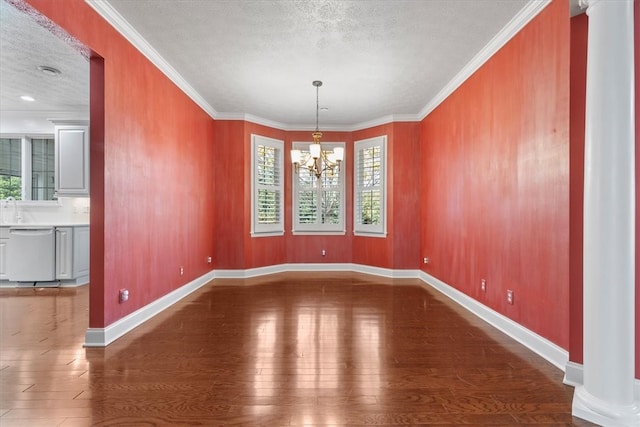 unfurnished dining area featuring crown molding, wood-type flooring, a textured ceiling, and an inviting chandelier