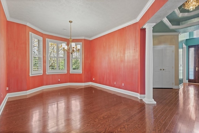 unfurnished dining area with ornamental molding, hardwood / wood-style floors, a notable chandelier, and ornate columns