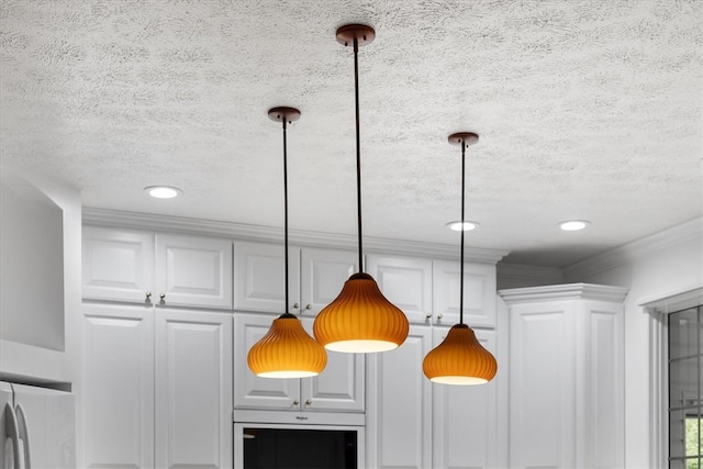 interior details with crown molding, a textured ceiling, white cabinetry, and decorative light fixtures